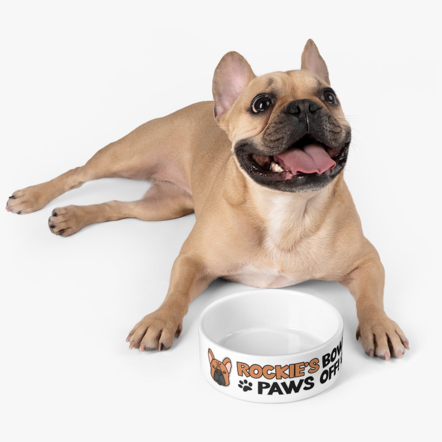 A cute french bulldog next to a personalized Dog Bowl with the phrase: "Rockie's Bowl Paws Off!"