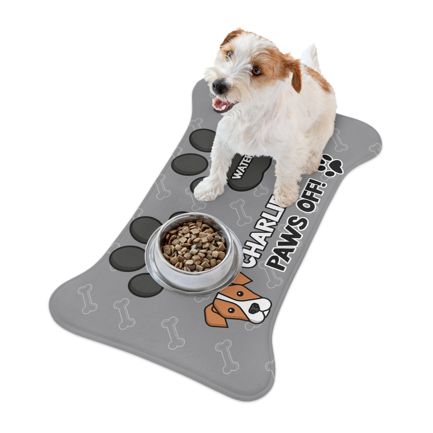 a cute dog on top of a personalized dog food mat with the a bone shape, two big paws with the words "Food" and "Water" at the top. And the face of a cute dog next to the words "Dog's Food Paws Off!". Color of the pet feeding mat is grey