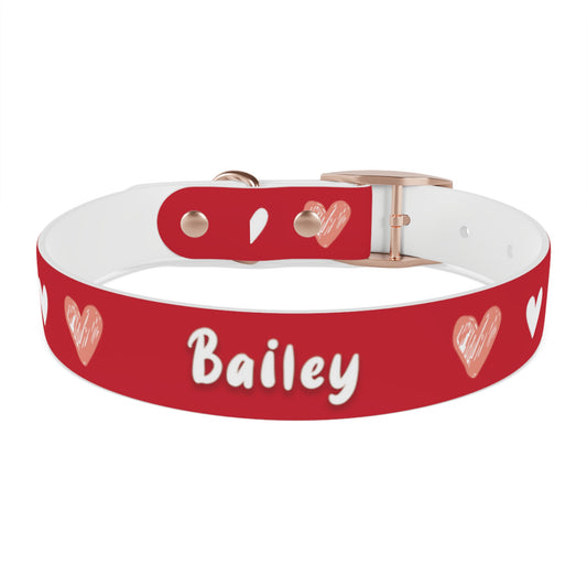 a dog collar with a beautiful hearts pattern design and the dog's name in the middle of the collar. The color of the dog collar is red
